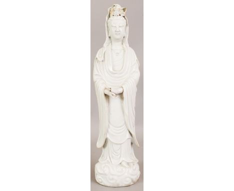 A LARGE CHINESE KANGXI PERIOD BLANC-DE-CHINE PORCELAIN FIGURE OF GUANYIN, circa 1700, standing in flowing robes on a cloud sc