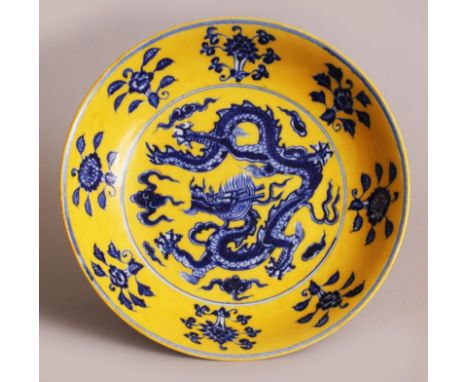 A CHINESE MING STYLE YELLOW GROUND BLUE & WHITE PORCELAIN DRAGON SAUCER DISH, the base with a six-character Xuande mark, 8.6i