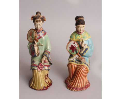 A PAIR OF 20TH CENTURY CHINESE GLAZED CERAMIC FIGURES OF SEATED LADIES, 9.75in & 9.25in high.