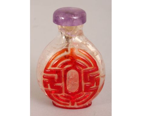 A CHINESE RED OVERLAY TRANSLUCENT GLASS SNUFF BOTTLE & AMETHYST STOPPER, decorated with a leaping carp and a wan swastika mot
