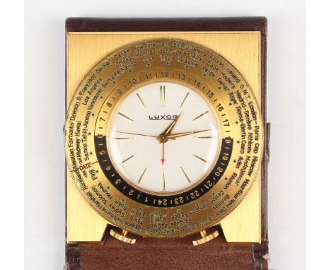 A Luxor brass cased world time travelling alarm clock, the signed white dial with gilt baton hour markers, the adjustable bez
