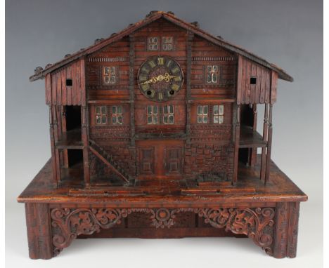 An impressive 19th century Swiss Black Forest carved walnut cased musical chalet clock with eight day movement striking hours