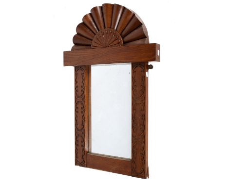 A 20th century oak framed mirror. The rectangular mirror in a carved frame featuring an arch to the top and scrolling details