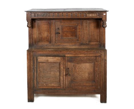 A 17th century and later oak court cupboard. Of peg construction, with carved panel to the top bearing later insert carved da