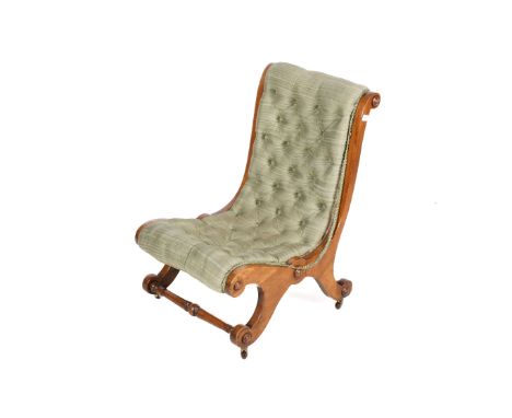 A Victorian walnut framed nursing chair. Upholstered in a green fabric with button back details, raised on four shapes suppor