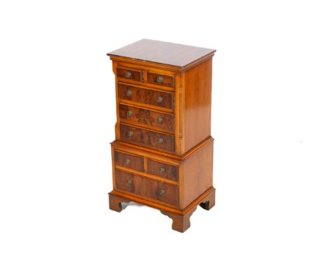 A reproduction one piece yew wood miniature chest on chest. The upper section having two short over three long drawers, the l