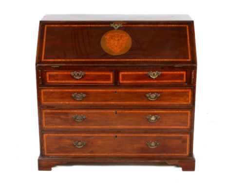 A late Victorian mahogany bureau. The slope having marquetry decoration featuring a ram's head, opening to reveal a fitted in