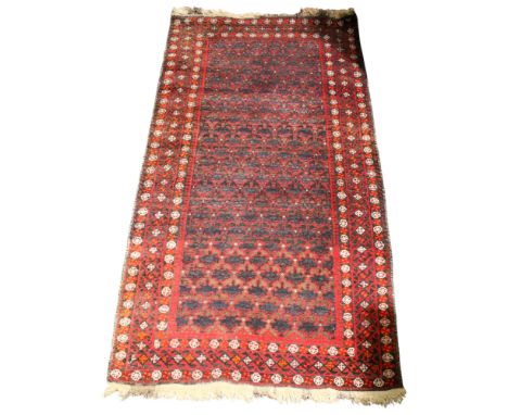 A 19th century Afghan style runner. With four geometric borders around a red central ground with many blue medallions. W204cm