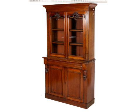 A Victorian mahogany two part glazed bookcase cabinet. Having glazed and carved two door upper section with cornice above con