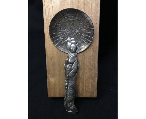 A Japanese silver caddy spoon in its original box, the spoon in the form of a lady under a parasol.