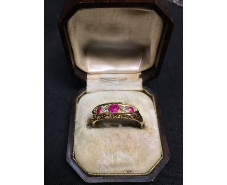 An 18ct gold five stone ruby and diamond dress ring, size N, approximately 3.5 grams.