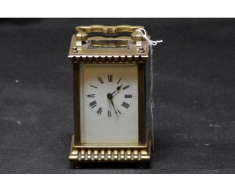 A 19th Century French lacquered and brass carriage clock with bevelled glass plate, raised on four turned supports, 15.5cm ta