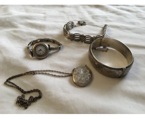 An assortment of silver jewellery including a locket and chain, a wristwatch, a bangle and a fine gate bracelet.