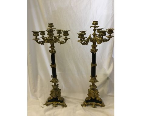 A large pair of French Empire style gilt six light candelabra, with turned metal column to a triform base, decorated with che