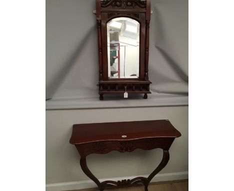A contemporary mahogany console table with pierced decoration, and a mahogany over-mirror with galleried glove compartment.