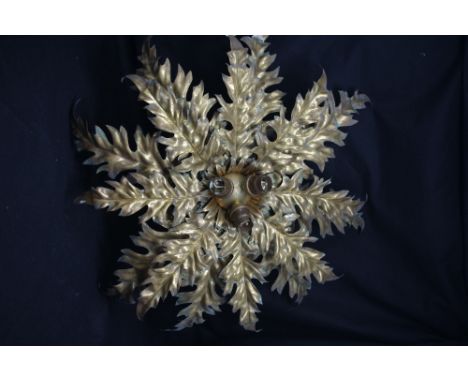 An Art Nouveau brass ceiling mounted light fitting in the form of outspread thistle foliage leaves.