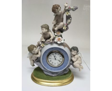 A Lladro mantle clock surmounted by cherubs.Approx 31cm including base