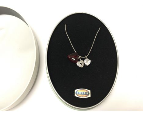 A Fossil necklace in original tin.