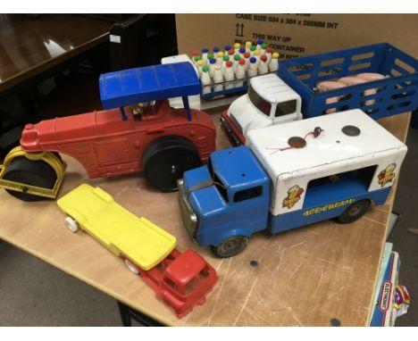 A collection of toys including tin plate Tonka vans including a Milk van, ice cream van, pig lorry and a plastic steam roller