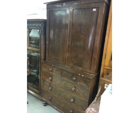 A Victorian Mahogany linen press with a pair of panel doors above two short and three long drawers