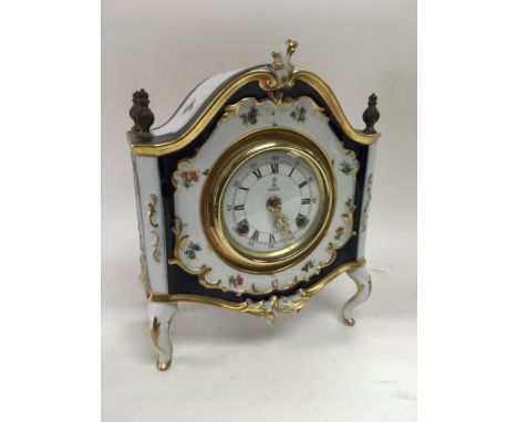 An 8 day Kaiser ceramic mantle clock with giltwork and floral spray decoration, approx 25cm height and approx 21cm width.