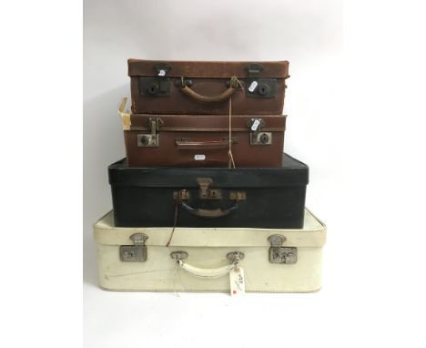 A collection of four vintage suitcases of various sizes, comprising two brown, one black and one white.