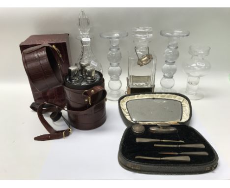 A glass decanter with silver base and wine label, glass ornaments including candlesticks, a cased silver manicure set (incomp