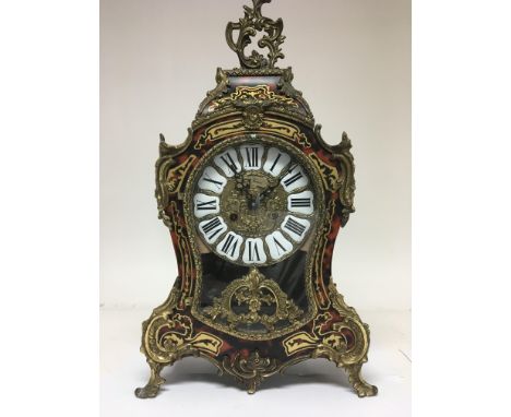 A French style mantle clock the dial with Roman numerals and visible pendulum