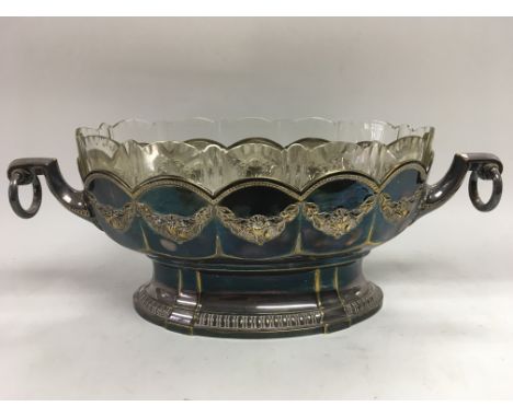 A silver plated two handled fruit bowl in the style of WMF fitted with a clear glass liner, approx height 17.5cm and approx l