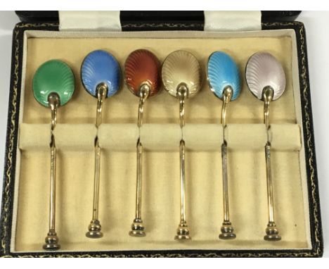 A cased set of quality enamel and silver gilt spoons. In a fitted case.