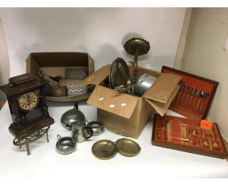 A collection of mixed metalware including a canteen of cutlery, a mantle clock, and odds