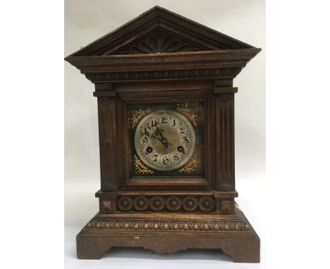 A oak cased mantle clock the silvered dial with Arabic numerals