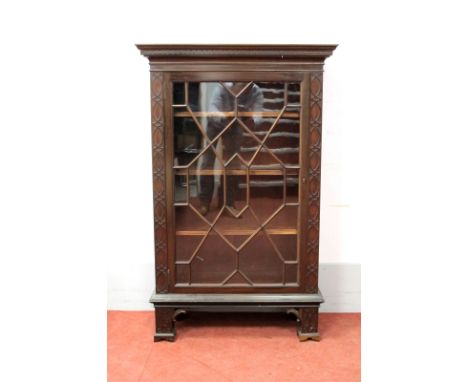 An Early XX Century Chinese Chippendale Style Mahogany Cabinet, with stepped cornice, glazed astragal door, blind fret sides,