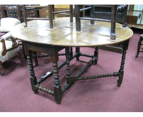 A Late XVII Century Joined Oak Drop Leaf Table, with oval top, single drawer, on bobbin and block supports united by stretche