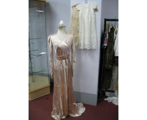 A Late 1930's Wedding Dress, in oyster satin, bias cut with small train, the bodice and wrist length sleeves decorated with b