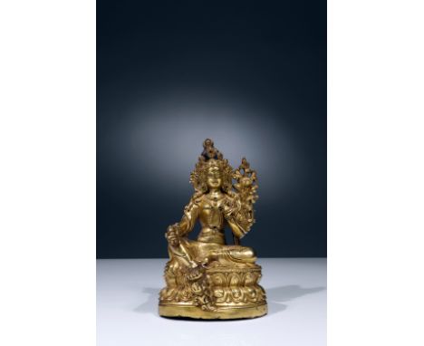 Bronze fire-giltTibet, 18th centuryDimensions: Height 13 cm by 8 cmWeight: 366,2 gramsGreen Tara seated on a double-reverse l