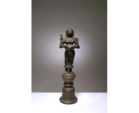 BronzeIndia, 18th centuryDimensions: Height 36 cmWeight: 3091 gramsThis bronze oil lamp shows a Hindu goddess standing on a b