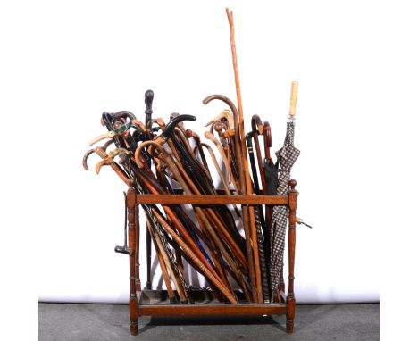 Large collection of walking sticks, umbrellas, in an oak stick stand.