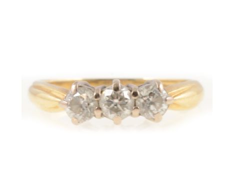 Diamond three stone ring, the brilliant cut stones claw set in an 18 carat yellow and white gold traditional three stone moun