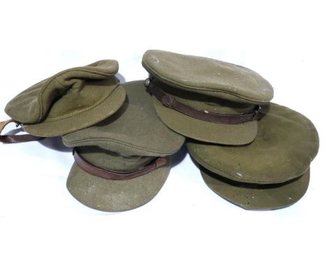 Four British WWI and WWII military visor caps in varying condition. P&amp;P Group 2 (£18+VAT for the first lot and £3+VAT for
