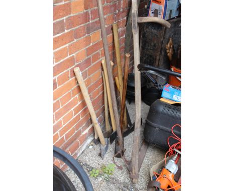 An assortment of vintage and modern hand tools including a large axe and scythe together with a cast iron Bushbaby lidded coo