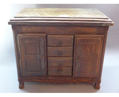 A late 19th Century/early 20th Century apprentice piece, a miniature model of an oak sideboard with four central drawers flan