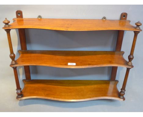 An early 20th Century mahogany three tier wall hanging shelf. 