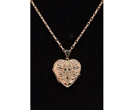 A 9CT GOLD HEART LOCKET PENDANT NECKLACE, the heart locket with an engraved foliate design, opens to reveal two photo compart