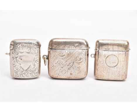 THREE EARLY 20TH CENTURY SILVER VESTAS, the first with an engine turned design and a vacant cartouche, striker to the base, f