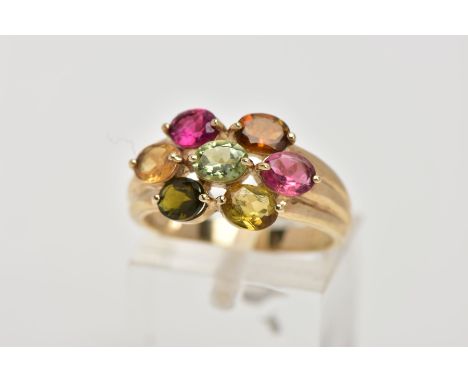 A 9CT GOLD GEM SET RING, of a cluster form, set with seven oval cut, differing colour gemstones assessed as tourmaline, textu