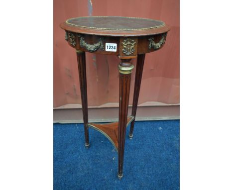 A LOUIS XVI STYLE CIRCULAR LAMP TABLE, with a brown leather inlay, on triple cylindrical fluted legs, united by a concave str
