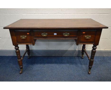 AN EDWARDIAN WALNUT SIDE TABLE, with two deep drawers flanking one drawer, on turned legs, and ceramic casters, width 122cm x