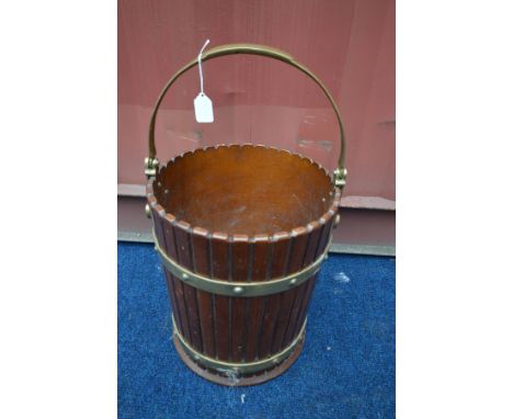 A COOPERED EFFECT AND BRASS BANDED BUCKET, with a brass handle, diameter 31cm x height 36cm (the item in this lot is the rema