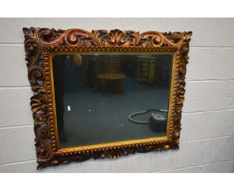 A 19TH CENTURY GILTWOOD WALL MIRROR, with open foliate scrolls, frame 97cm x 82cm, mirror 70cm x 55cm (the item in this lot i